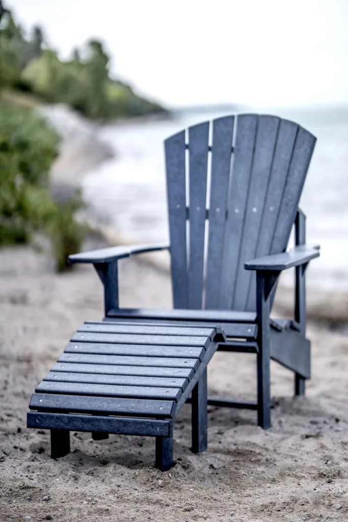 Navy Generations Premium Adirondack Footrest in front of a Adirondack chair on the coast