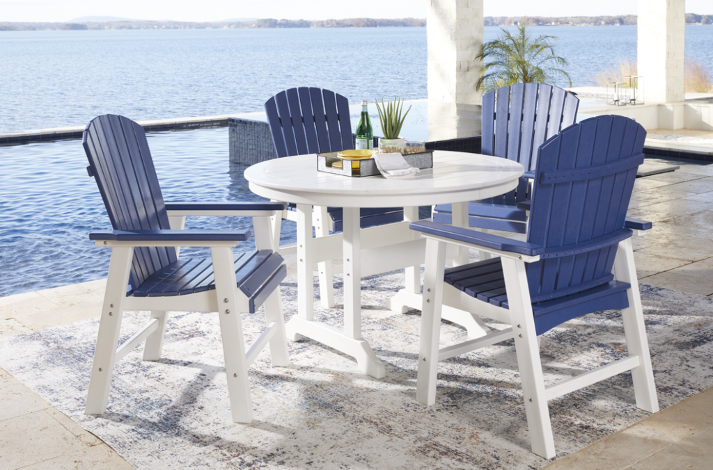 Four beautiful blue and white chairs surrounding a circular white table on a coastal porch