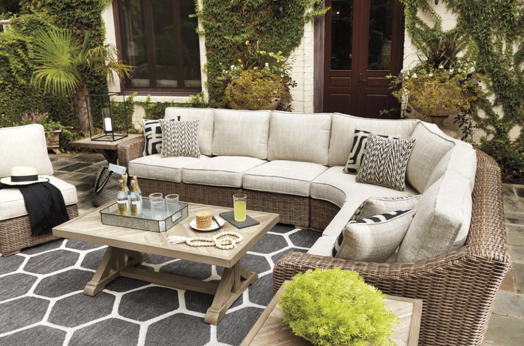 A large outdoor couch in L shape surrounding an outdoor table, with lots of earthy colors.