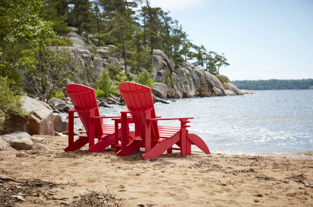 Red Generations Adirondack Footrest and Chair on the coastline looking out onto the water