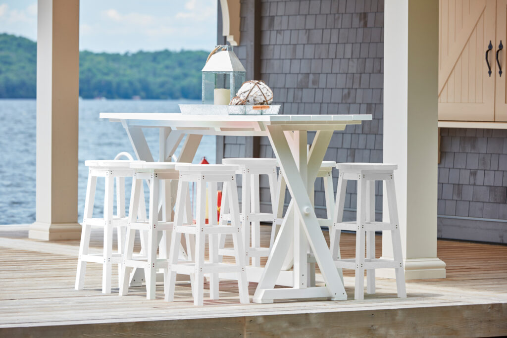 72" Rectangular Harvest Bar Table in White surrounded by stools on a porch